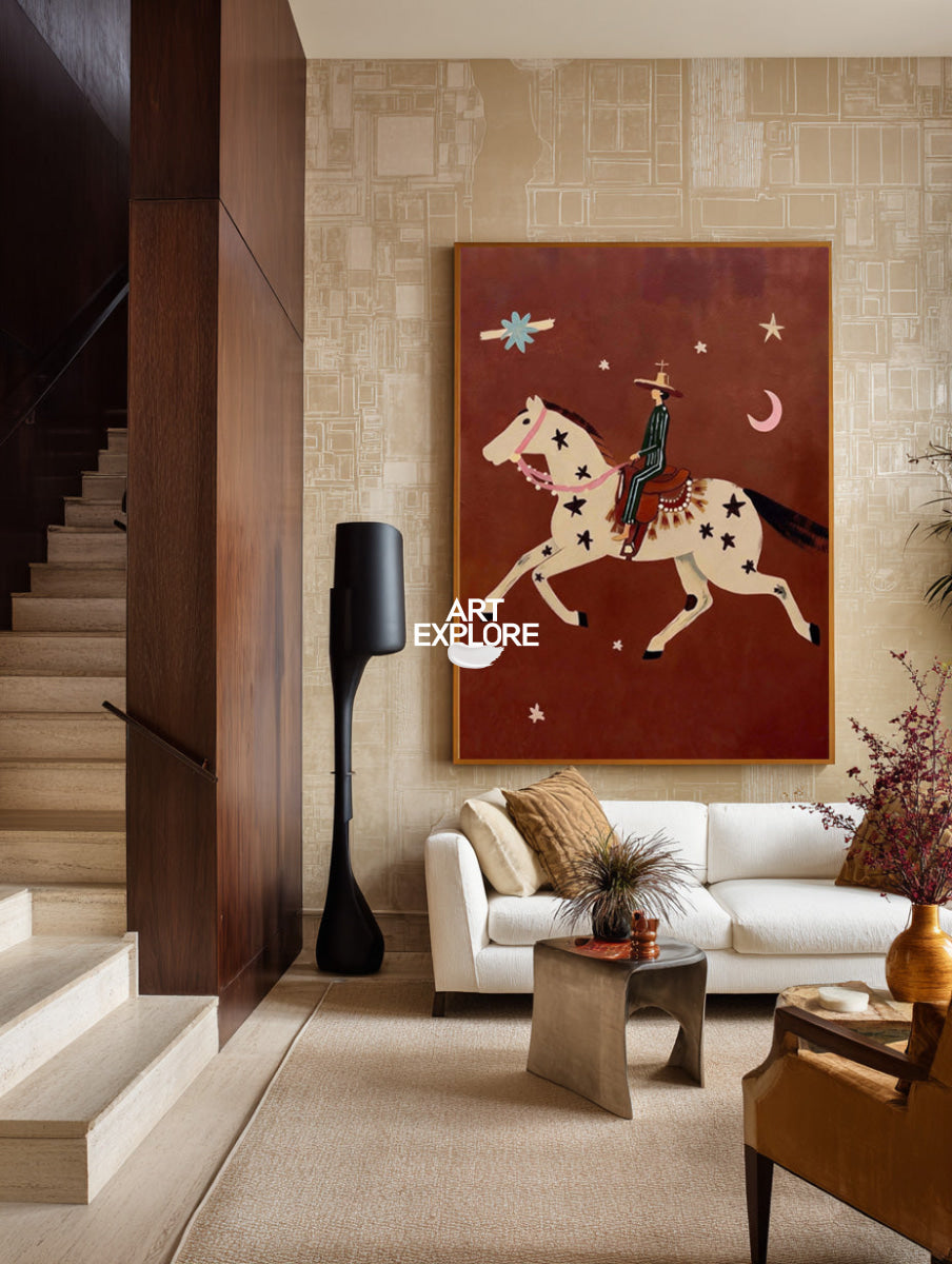 A framed art print depicting a stylized cowboy riding a star-spangled horse against a reddish-brown background, displayed on a beige patterned wall in a modern living room setting.